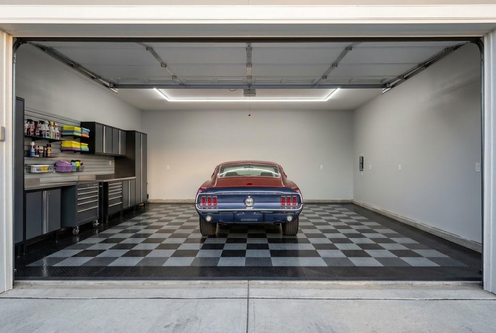 Classic Mustang displayed on a checkerboard garage floor beside dark cabinets and organized detailing supplies.
