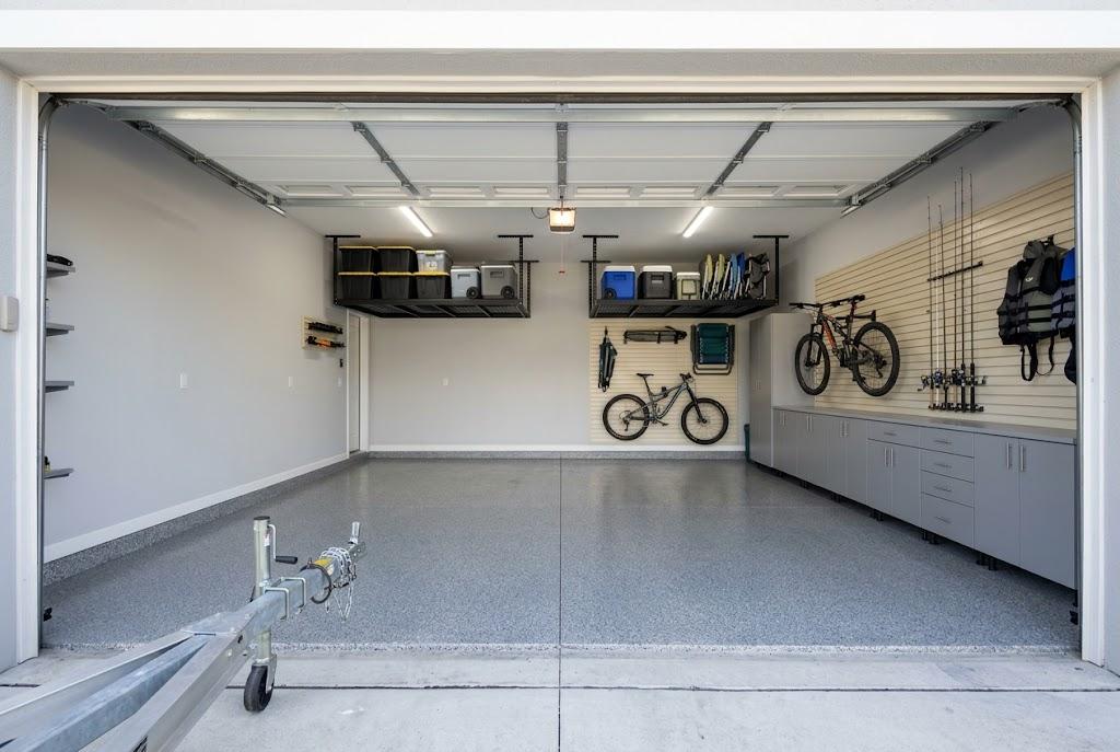 Organized garage with bicycles, fishing rods, outdoor gear, overhead racks and cabinets, with a trailer hitch visible in front.